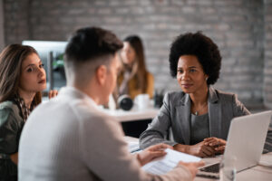 Young couple talking with their financial advisor about their future investments. Focus is on African America financial advisor.